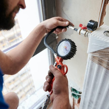 Male worker checking gas tightness of heating system.